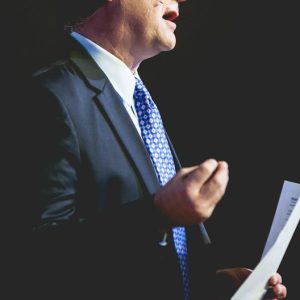 a man in a suit and tie holding a piece of paper