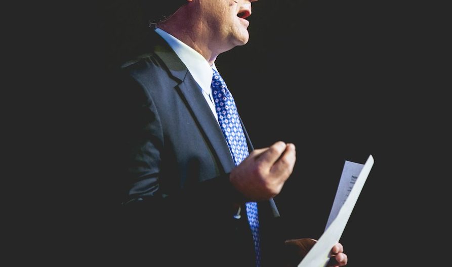 a man in a suit and tie holding a piece of paper